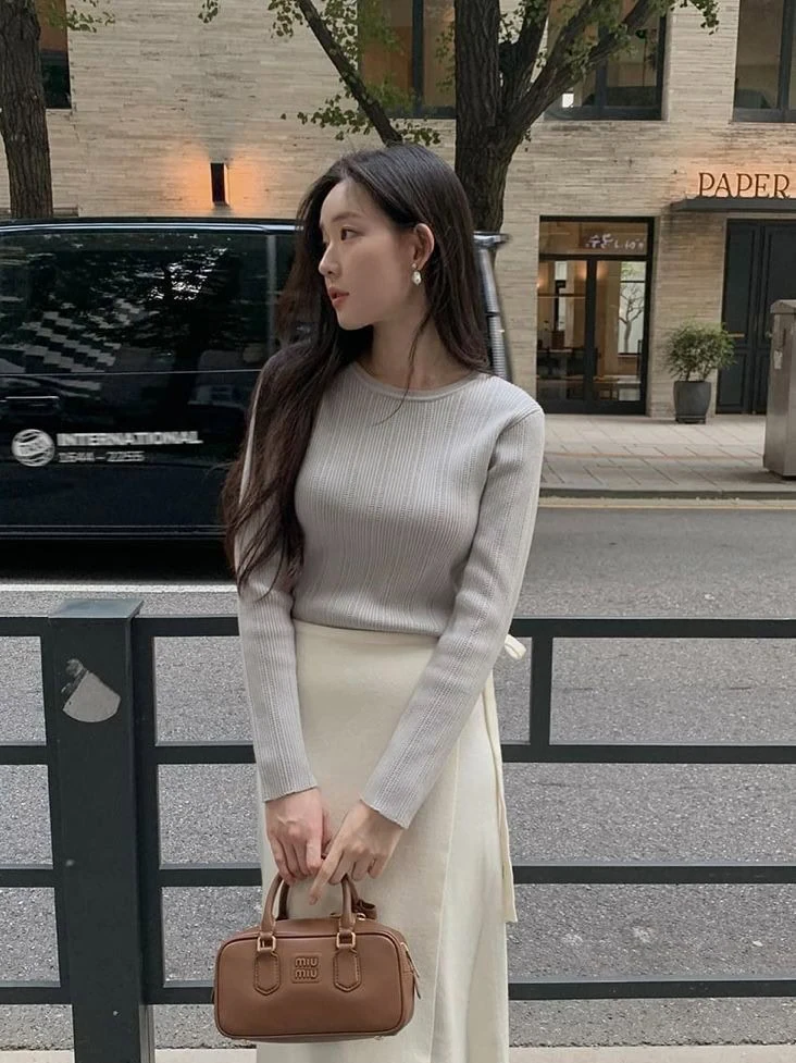 A ribbed sweater provides warmth while keeping the outfit fitted and neat. A midi skirt adds movement and keeps the look balanced.

This combination works for casual outings or light workdays. With a coat or cardigan, it becomes a reliable winter outfit that feels both cozy and thoughtful.